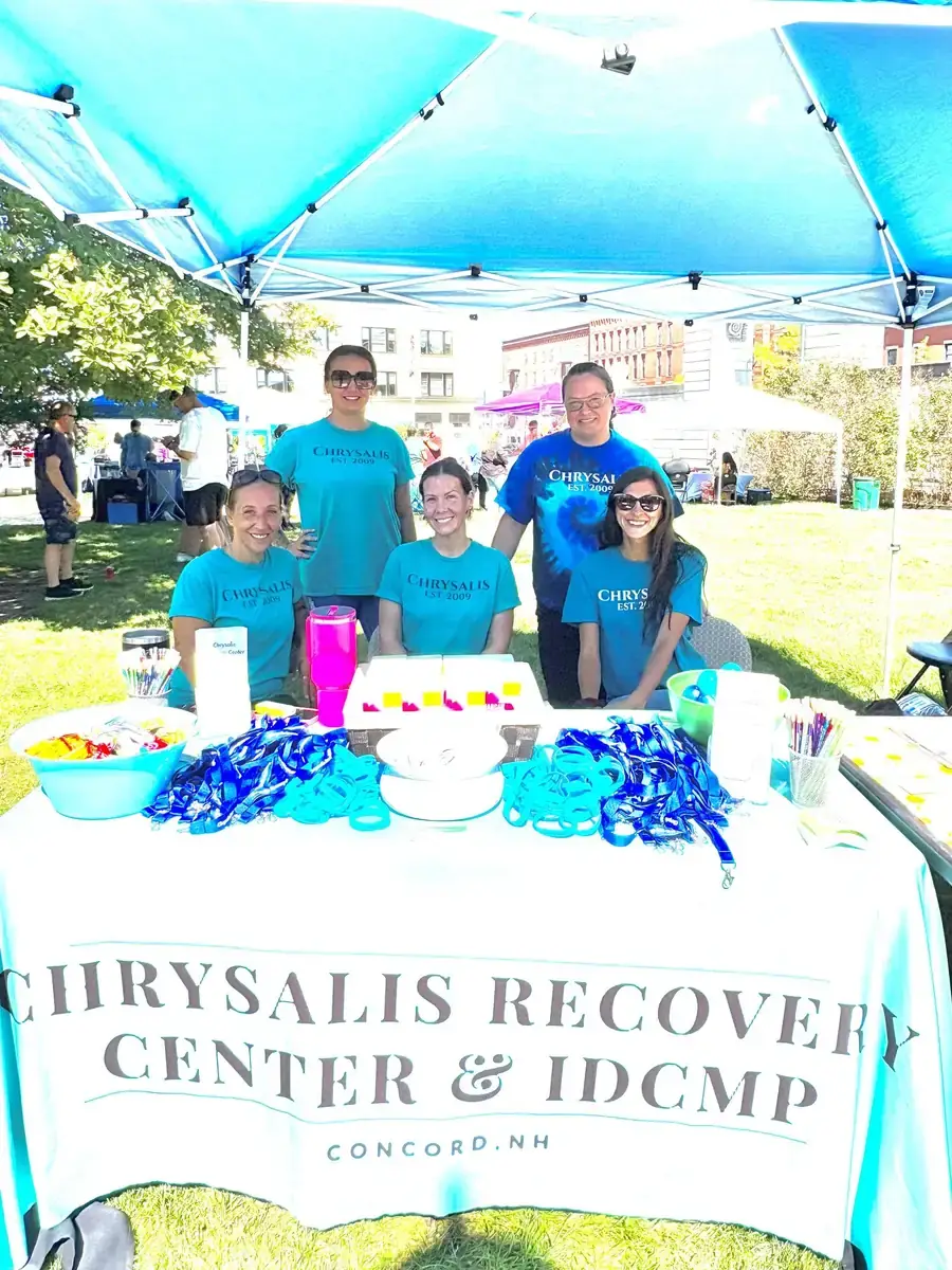 Chrysalis Recovery Center staff gathered at a 2025 recovery event booth