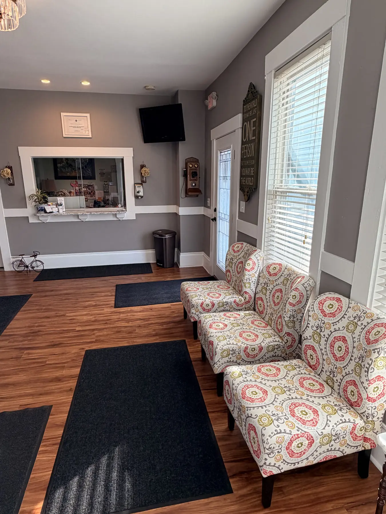 Waiting room lobby with patterned chairs, reception window, and entry door at the Concord, NH office