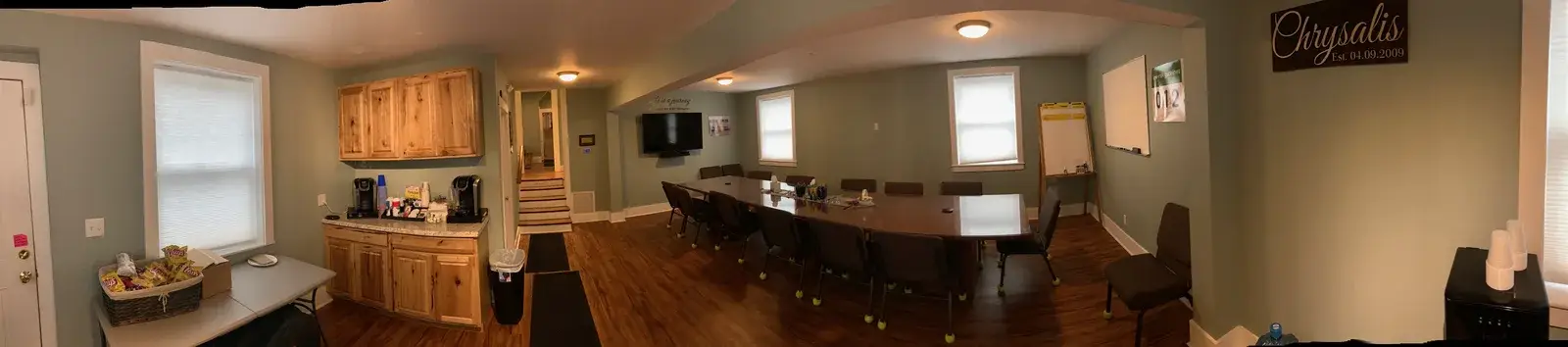 Downstairs conference room with a long table and warm lighting at the Concord, NH office